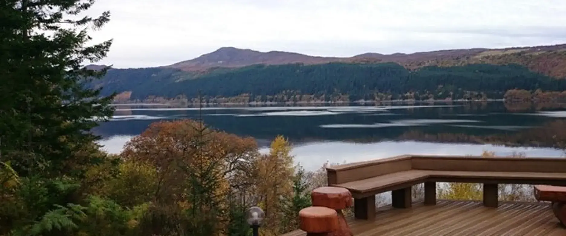 A beautiful decking with a view over a lake sorrounded by trees
